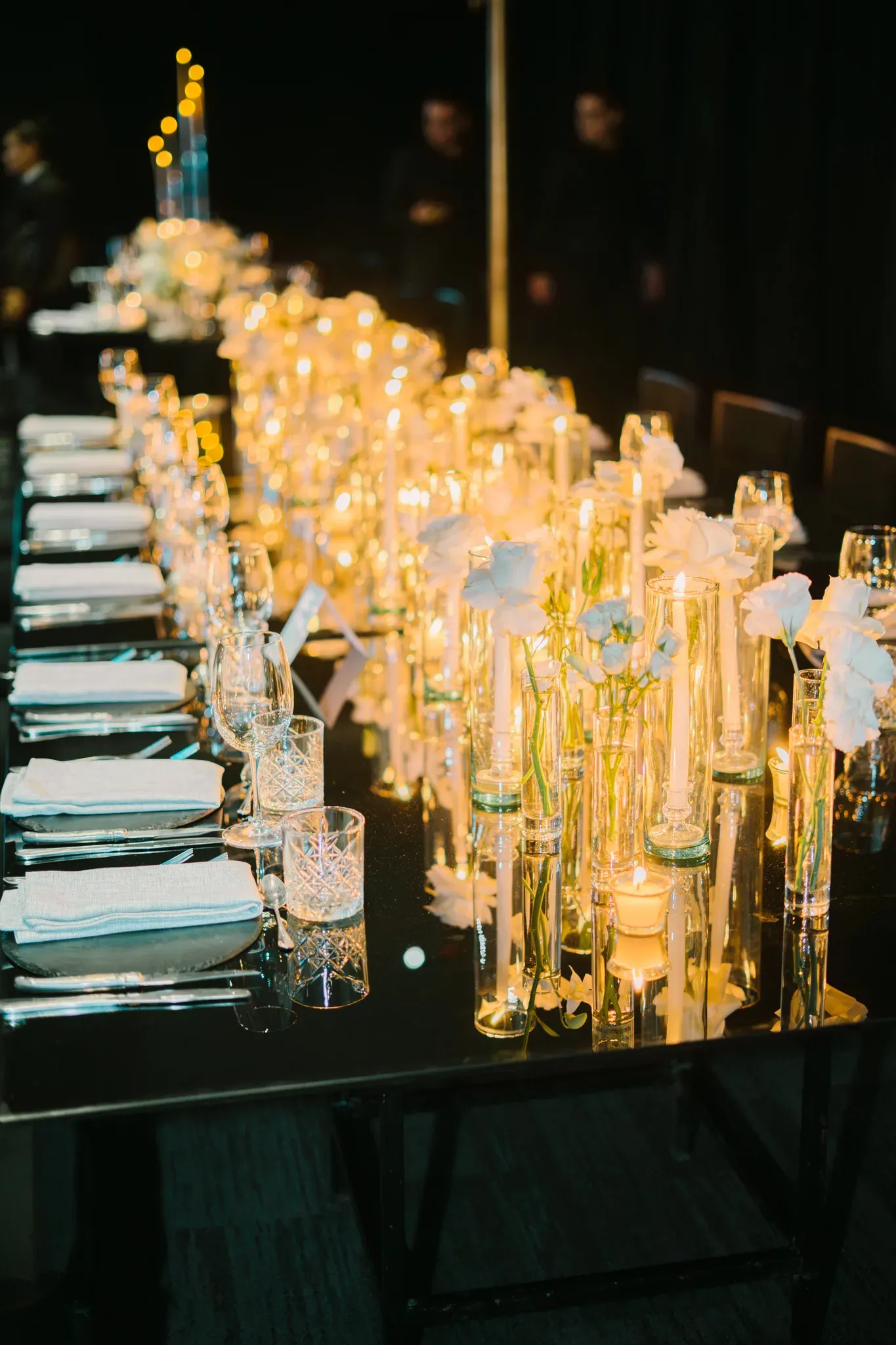 Decoración de mesa de boda elegante con velas, flores blancas en tubos de vidrio sobre mesa espejo